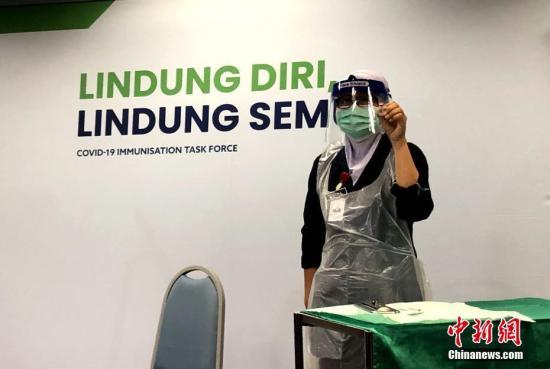 资料图：马来西亚一名医务人员正在展示疫苗。中新社发 温俊钦 摄