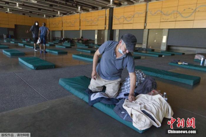 资料图：美国俄勒冈州波特兰市，一名男子在紧急避难中心避暑。